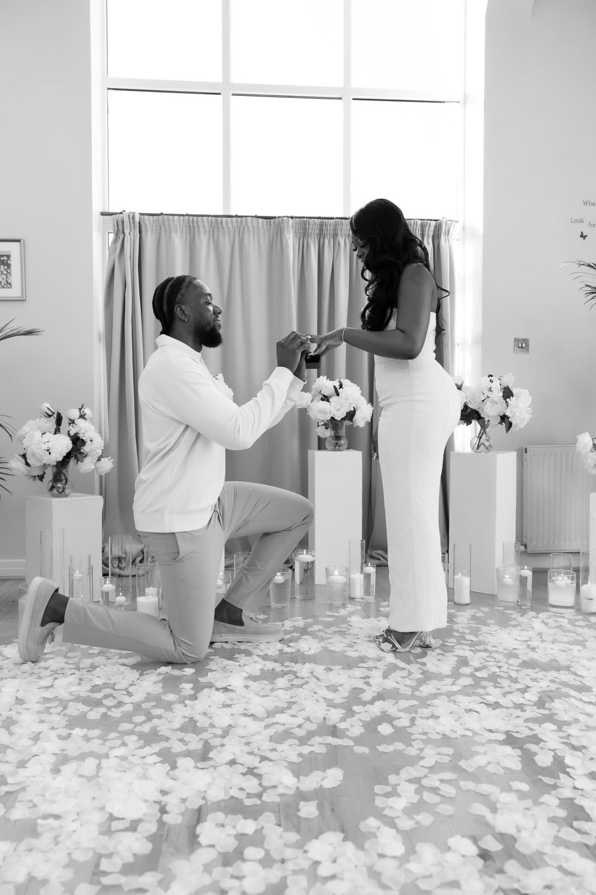 Black and white photo of a proposal among plinths and petals