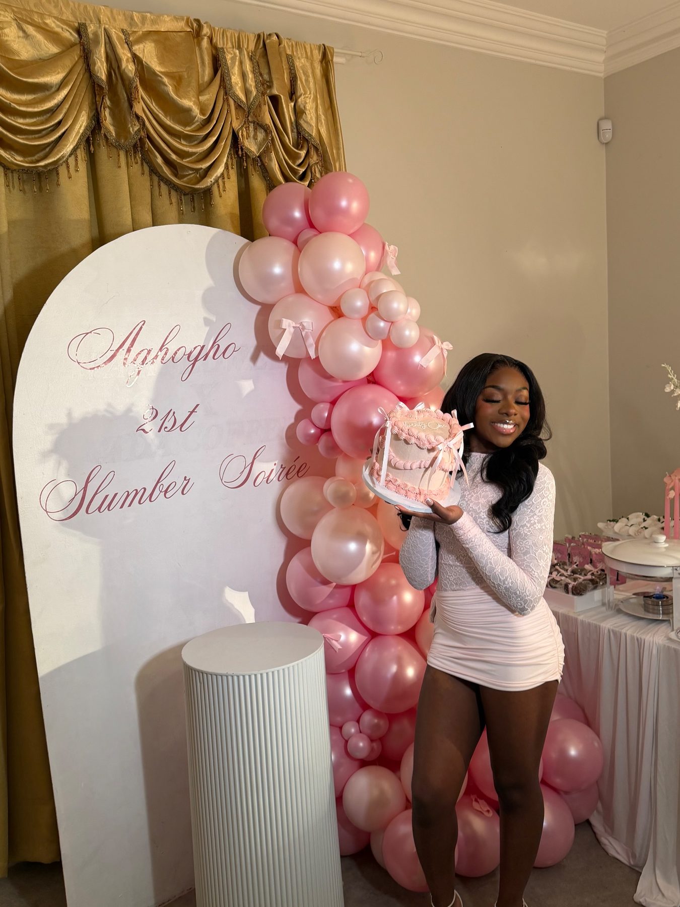 Birthday guest in front of a slumber soirée arch and balloons