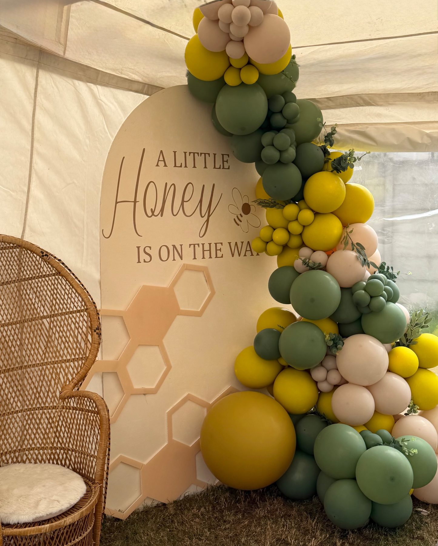 A Little Honey Is On The Way arch with sage and mustard balloons