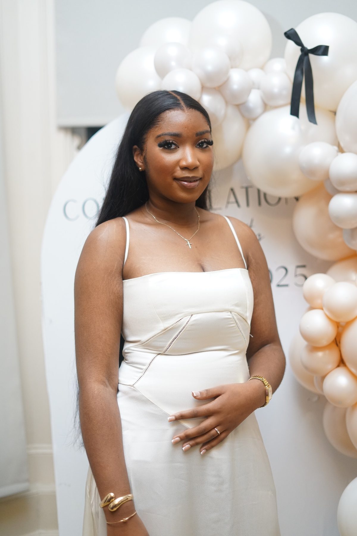 Portrait beside a white and pearl balloon installation